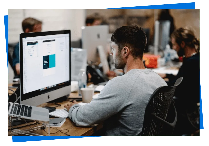 Equipe corporativa trabalhando em iMac com layout de site profissional em desenvolvimento